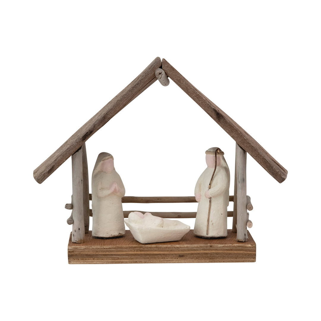 Small nativity scene with three figures and a wooden shelter on a white background