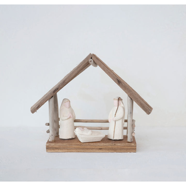 Small nativity scene with wooden stable on a white background