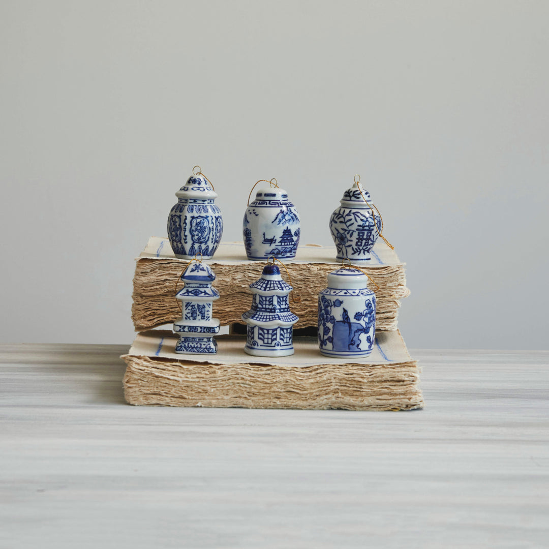 Set of six blue and white ceramic jars on a woven basket against a plain background