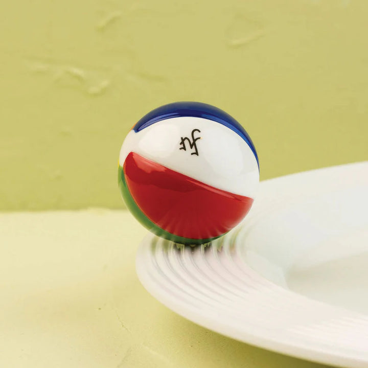 Colorful ball with a logo on a white surface against a green background
