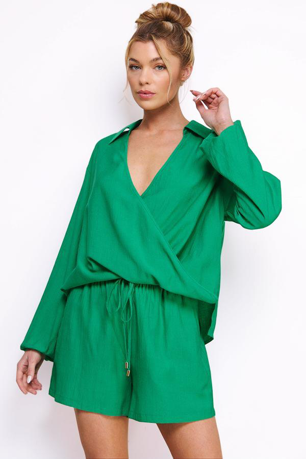 Woman wearing a green romper against a white background