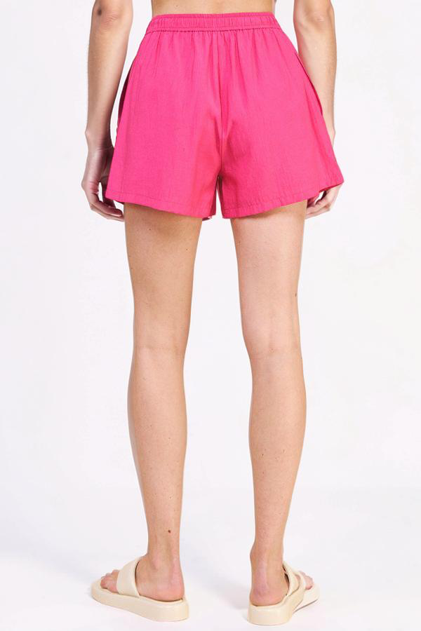 Person wearing bright pink shorts on a white background