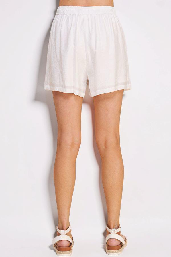 White shorts worn by a person on a plain background