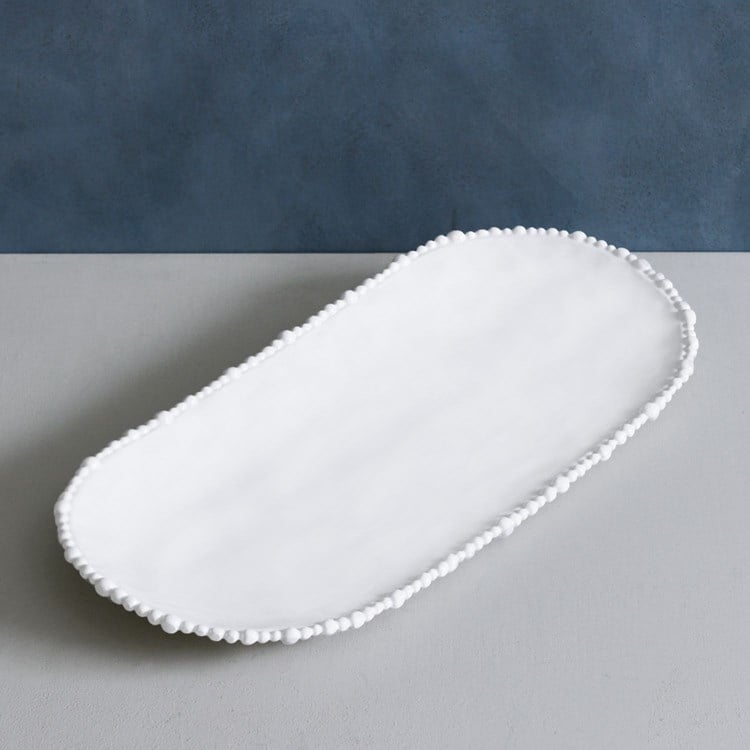 White platter on a gray surface with a blue background