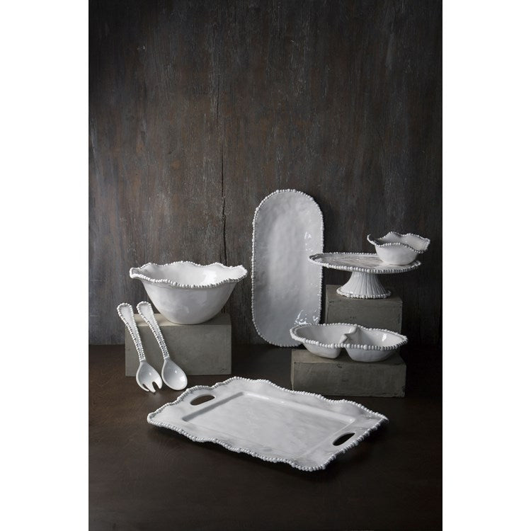 Set of white melamine dishes and utensils on a dark background