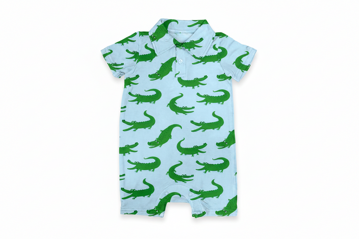 Baby romper with green alligator pattern on a light blue background
