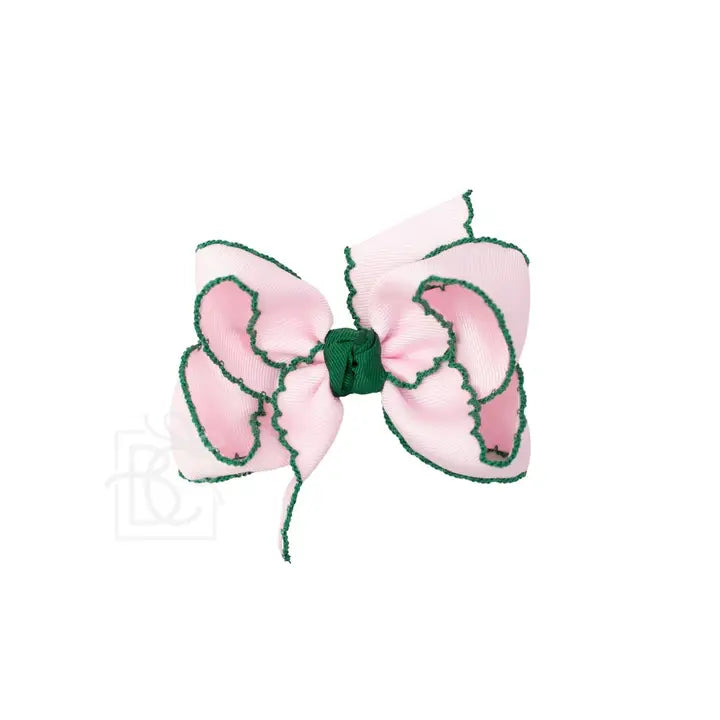 Pink bow with green center on a white background