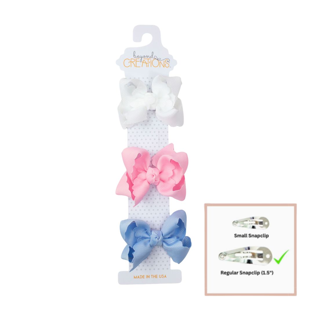 Set of hair clips with pink and blue bows on a white background