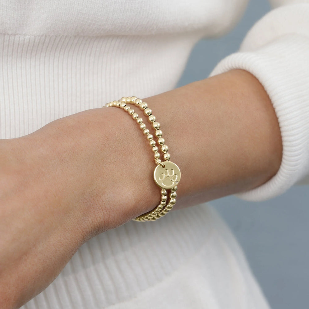 gold beaded bracelet with clemson tigers charm on wrist - enewton