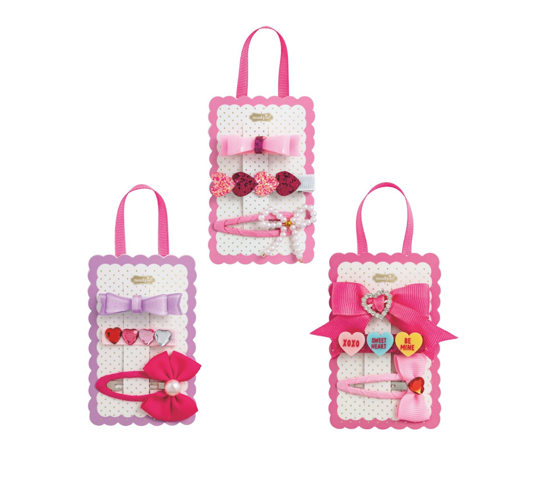 Set of three hair accessory packages with bows and clips on a white background