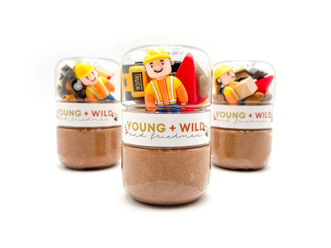 Three small jars with toy figures and 'Young + Wild' branding on a white background