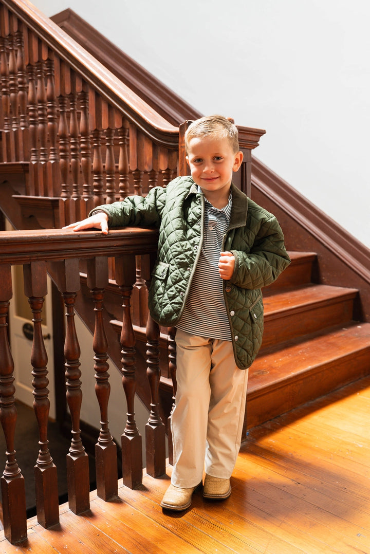 little boy wearing Green Derby Quilted Jacket in front of wooden staircase