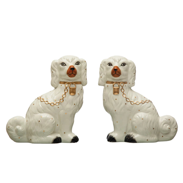 A pair of white dolomite Staffordshire dog figurines with hand-painted details and gold-colored collars.