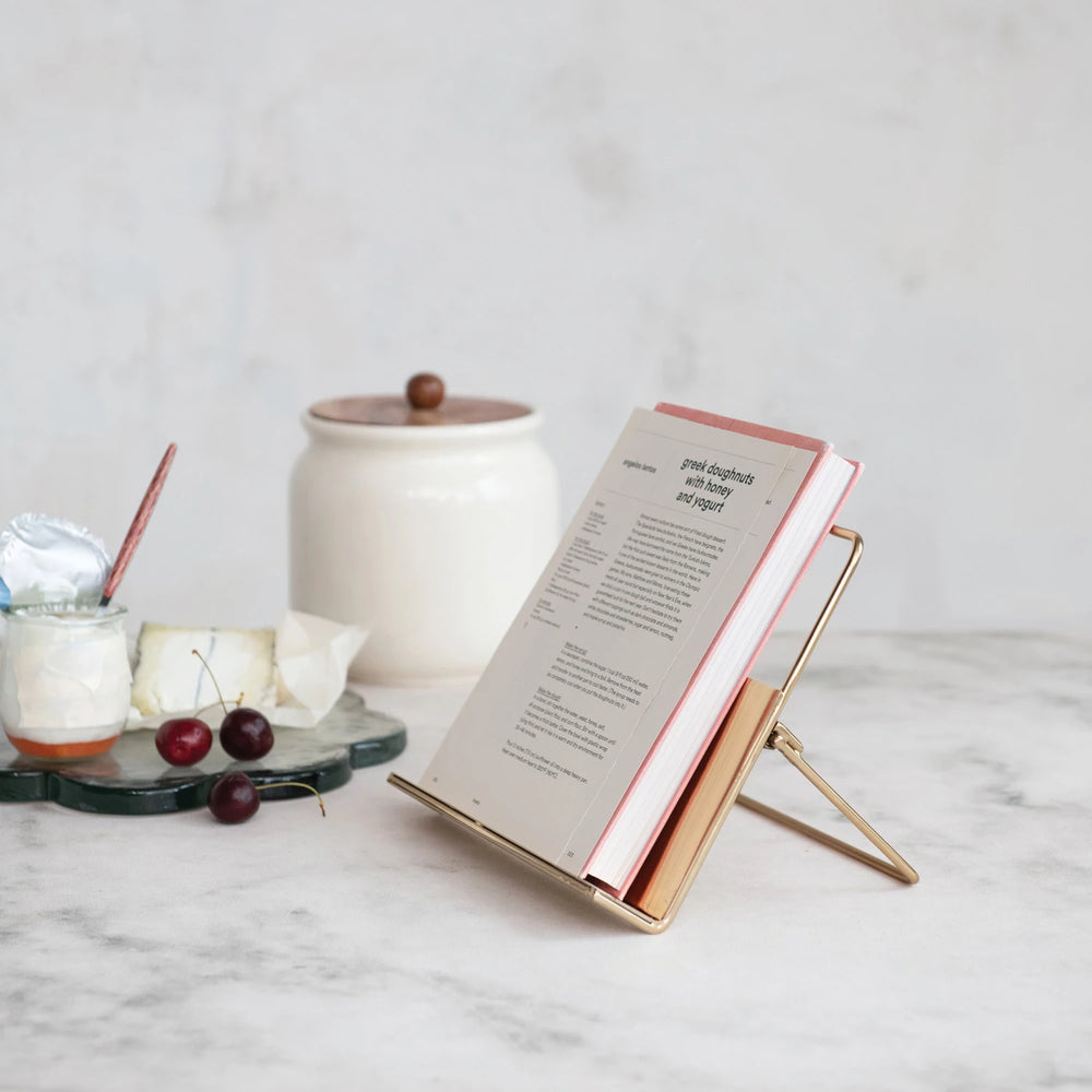 Book on a gold stand with a white background