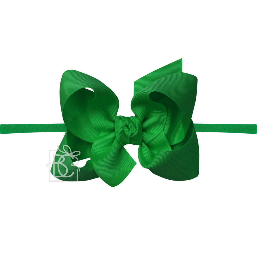 Green hair bow with a white logo on a white background