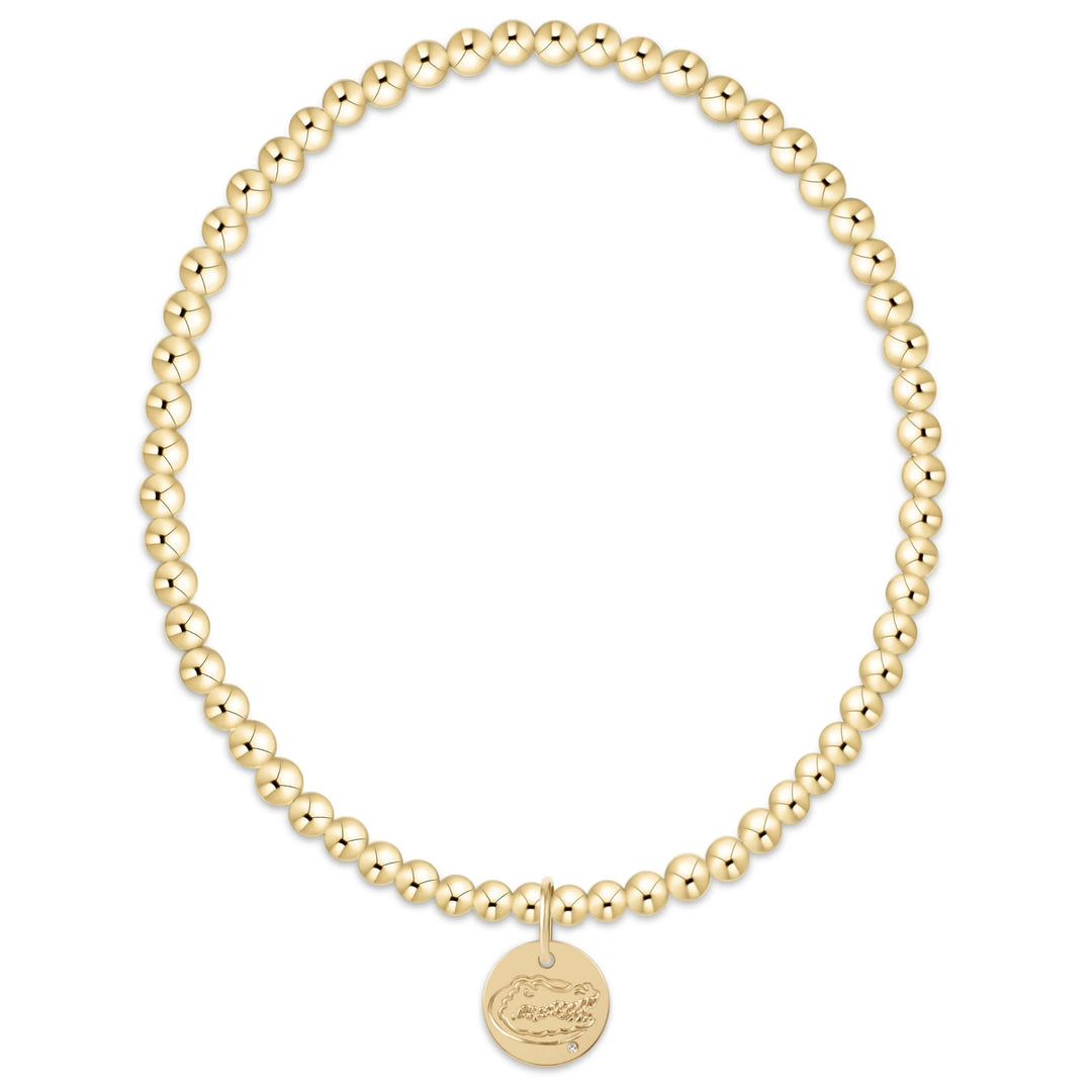 Gold beaded bracelet with a round disc with University of Florida Gators on a white background
