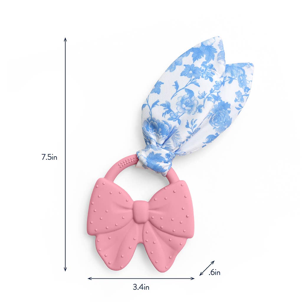 Pink bow-shaped teether with blue floral bandage on a white background