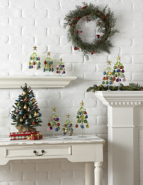 Decorative Christmas trees and wreath on a white brick wall background