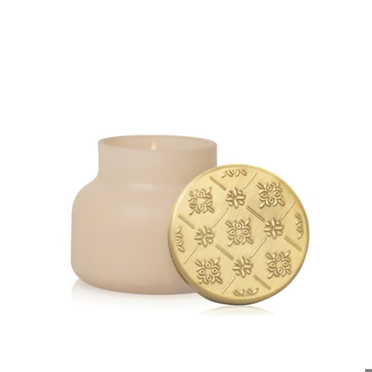 Beige candle with decorative lid on a white background