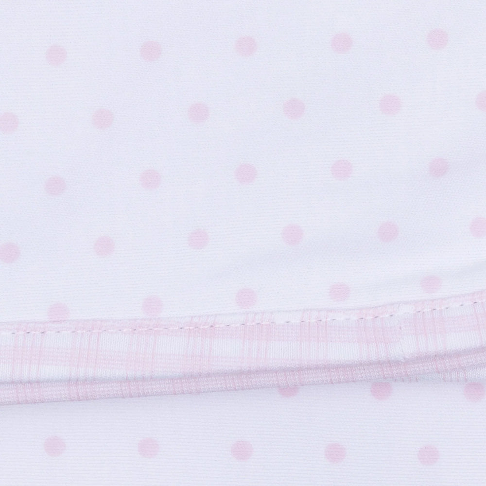 Close-up of a pink polka dot fabric with a gingham trim.