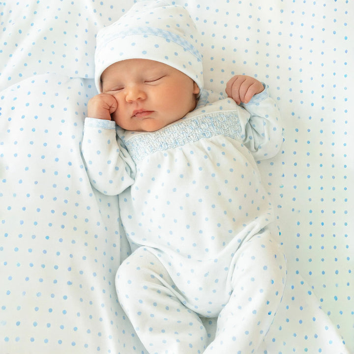 Newborn baby sleeping in a polka dot crib sheet