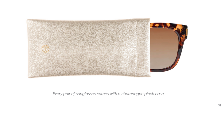 A pair of sunglasses partially pulled from a champagne-colored textured leather case on a white background, with small text below stating, 'Every pair of sunglasses comes with a champagne pinch case.'.