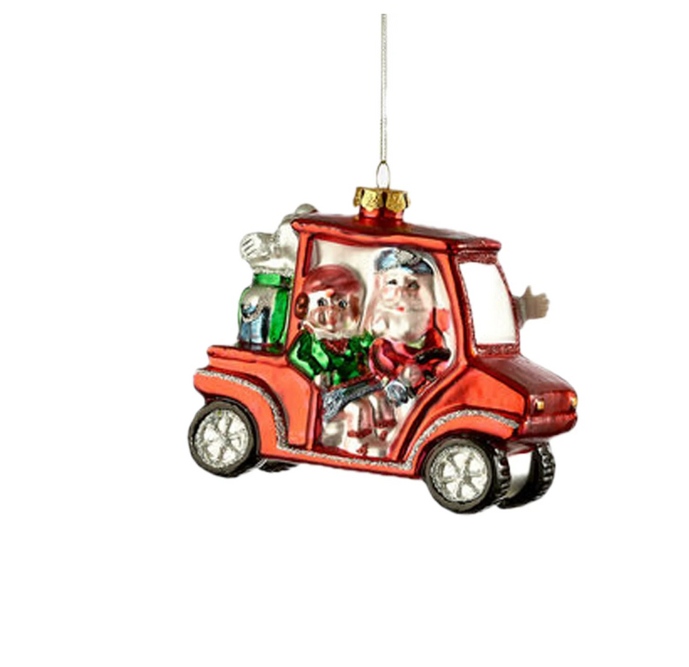 Decorative Christmas ornament of Santa Claus driving a golf cart with a dog inside, on a white background.