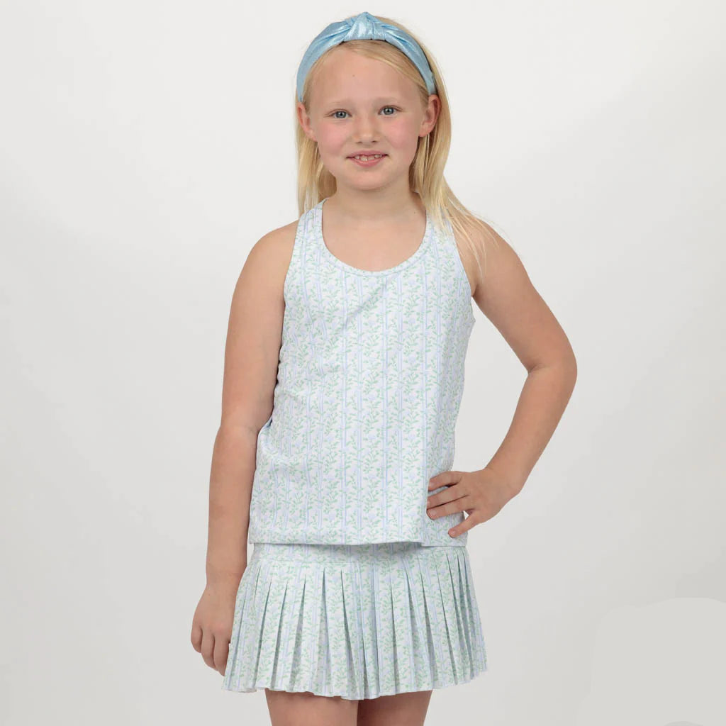 Young girl wearing a light blue sleeveless top and pleated skirt with a matching headband on a white background.