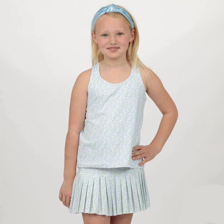 Young girl wearing a light blue sleeveless top and pleated skirt with a matching headband on a white background.