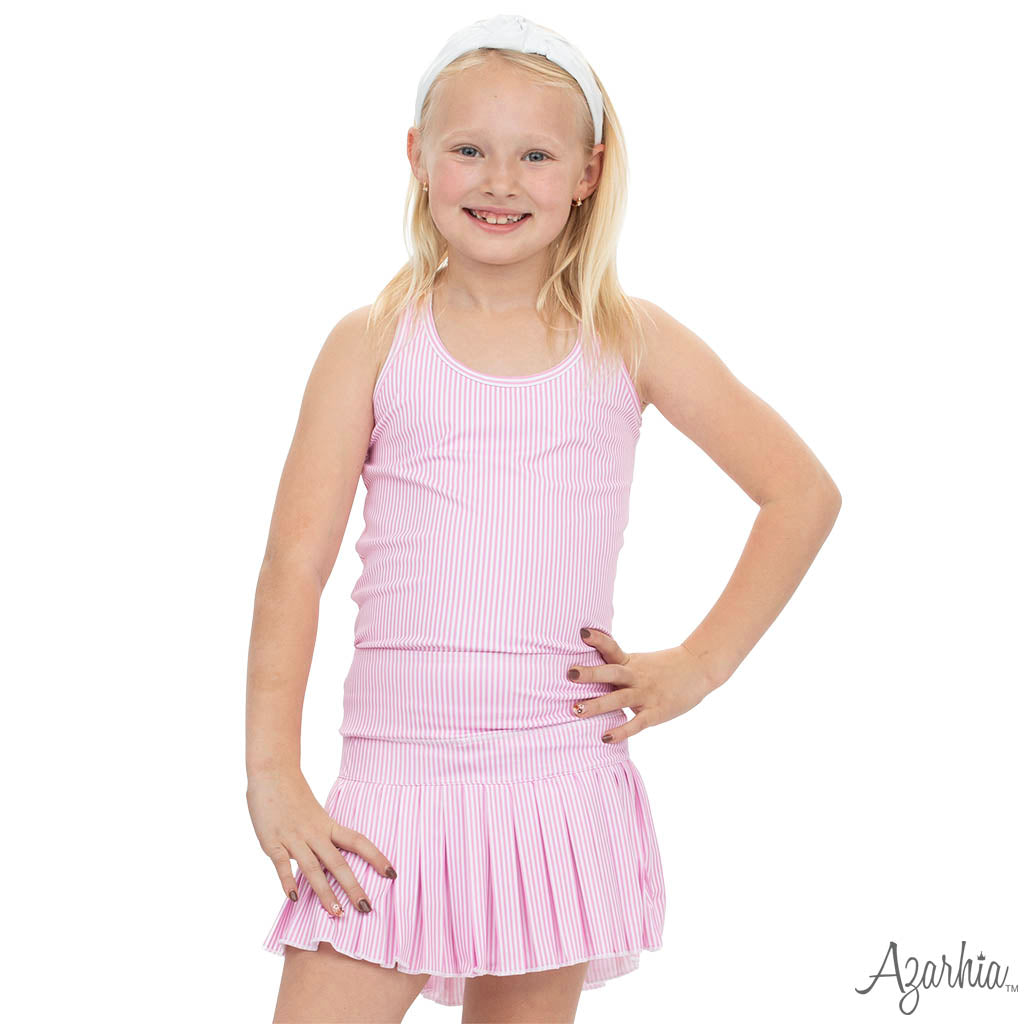 Young girl wearing a pink dress with pleated skirt on a white background