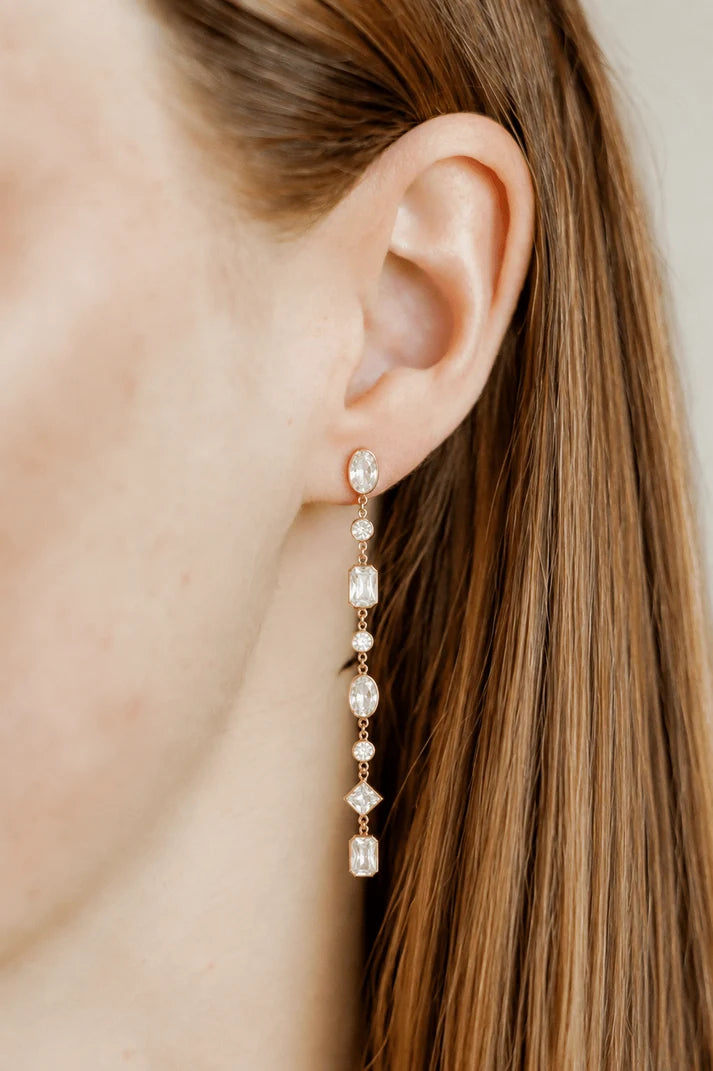 Jane long gold crystal statement earring worn on the ear for an elegant occasion look