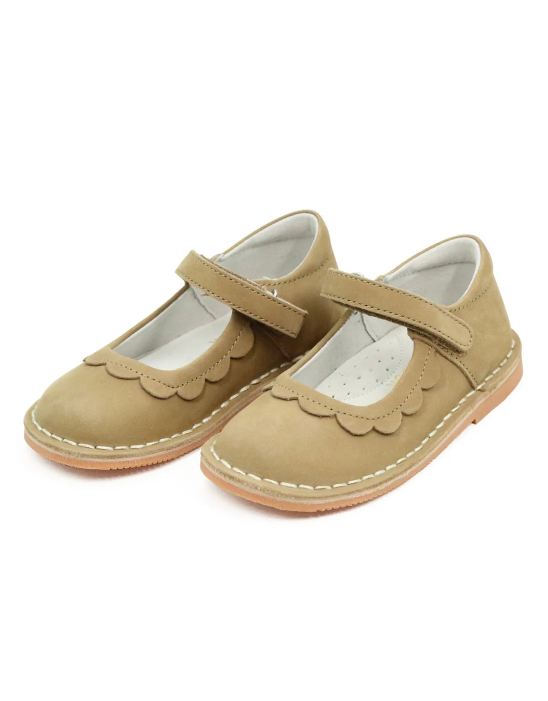 Pair of beige children's shoes with a strap on a white background
