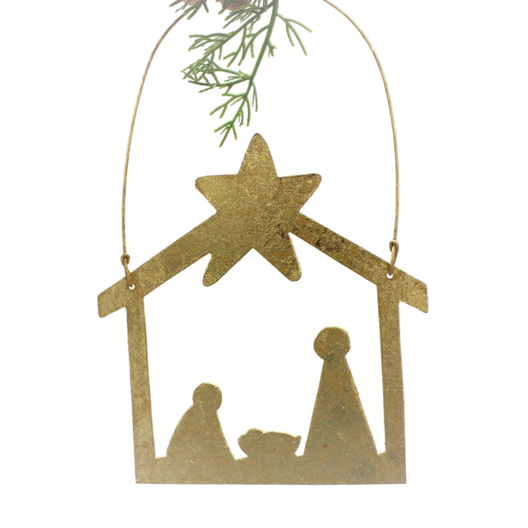 Gold nativity scene ornament with star on a white background