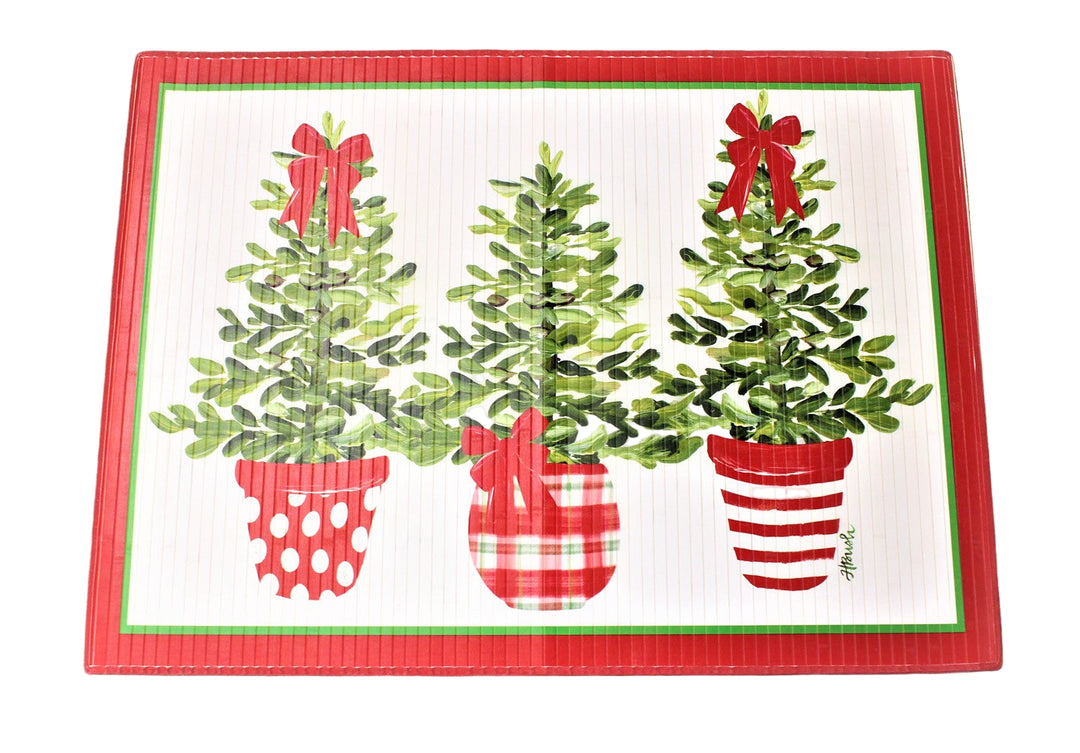 Decorative mat with Christmas tree designs and red bows on a white surface