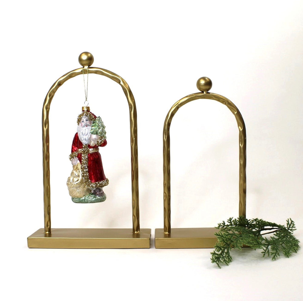 Decorative brass horse shoes with a Santa Claus ornament on a white background