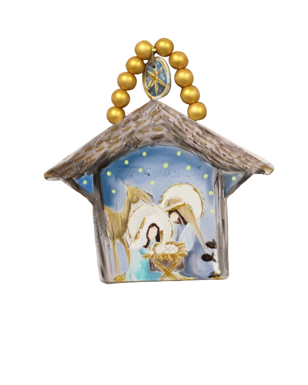Decorative ornament with nativity scene and gold beads on a white surface