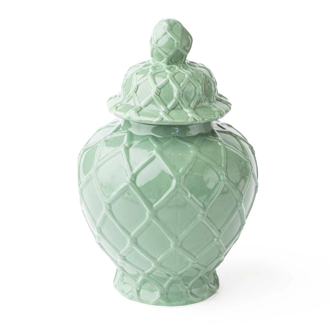 Green ceramic jar with textured lid on a white background