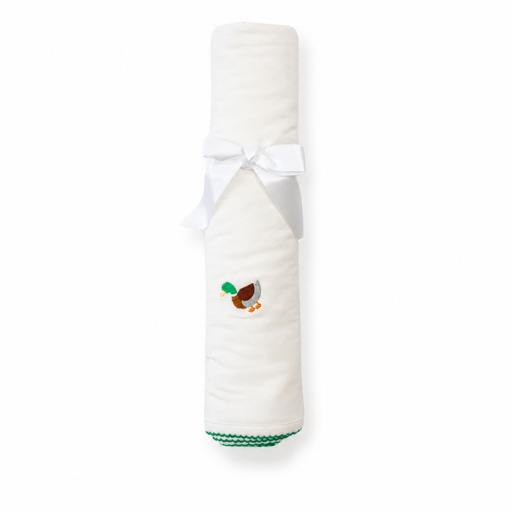 Folded white blanket with a small embroidered design on a white background