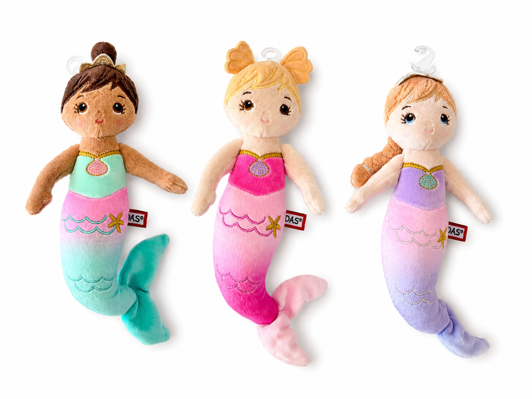 Three mermaid plush toys with different hair colors and pastel gradient tails, displayed side-by-side on a white background. Each plush has a small red tag with the brand name 'KASP'.