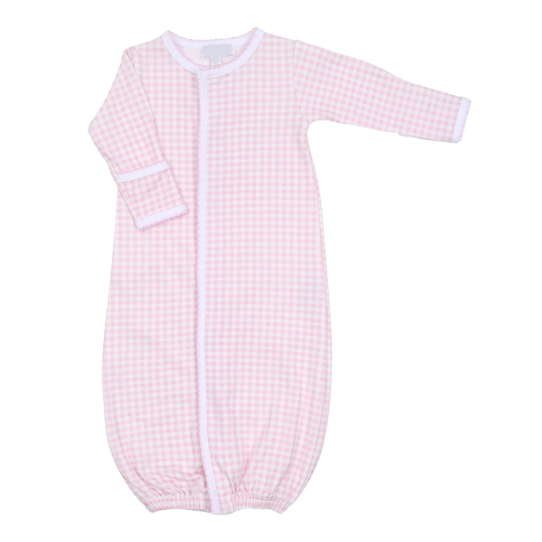 Pink checkered baby converter gown with white piping on a white background