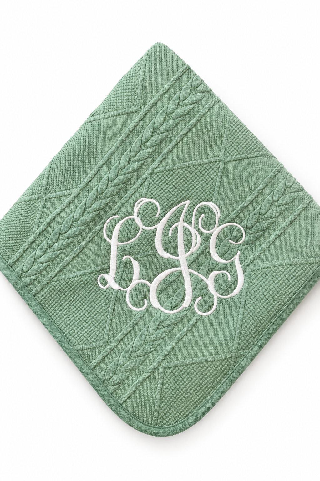 A sage green textured baby blanket with a diamond and cable knit pattern, featuring a white embroidered monogram 'BJS' in the center, shown on a plain white background.