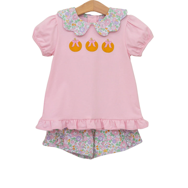 Pink children's outfit with floral collar and shorts on a white background
