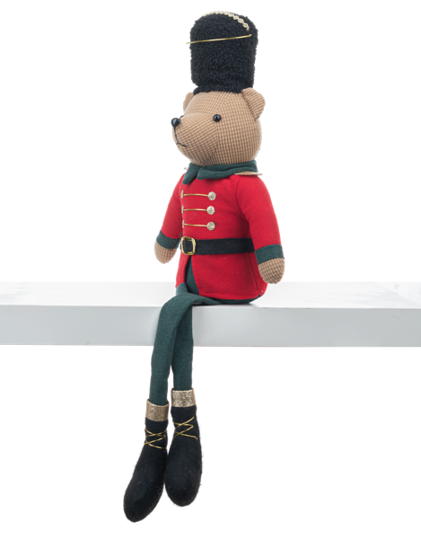 Stuffed toy bear dressed in a red uniform with a black hat on a white surface