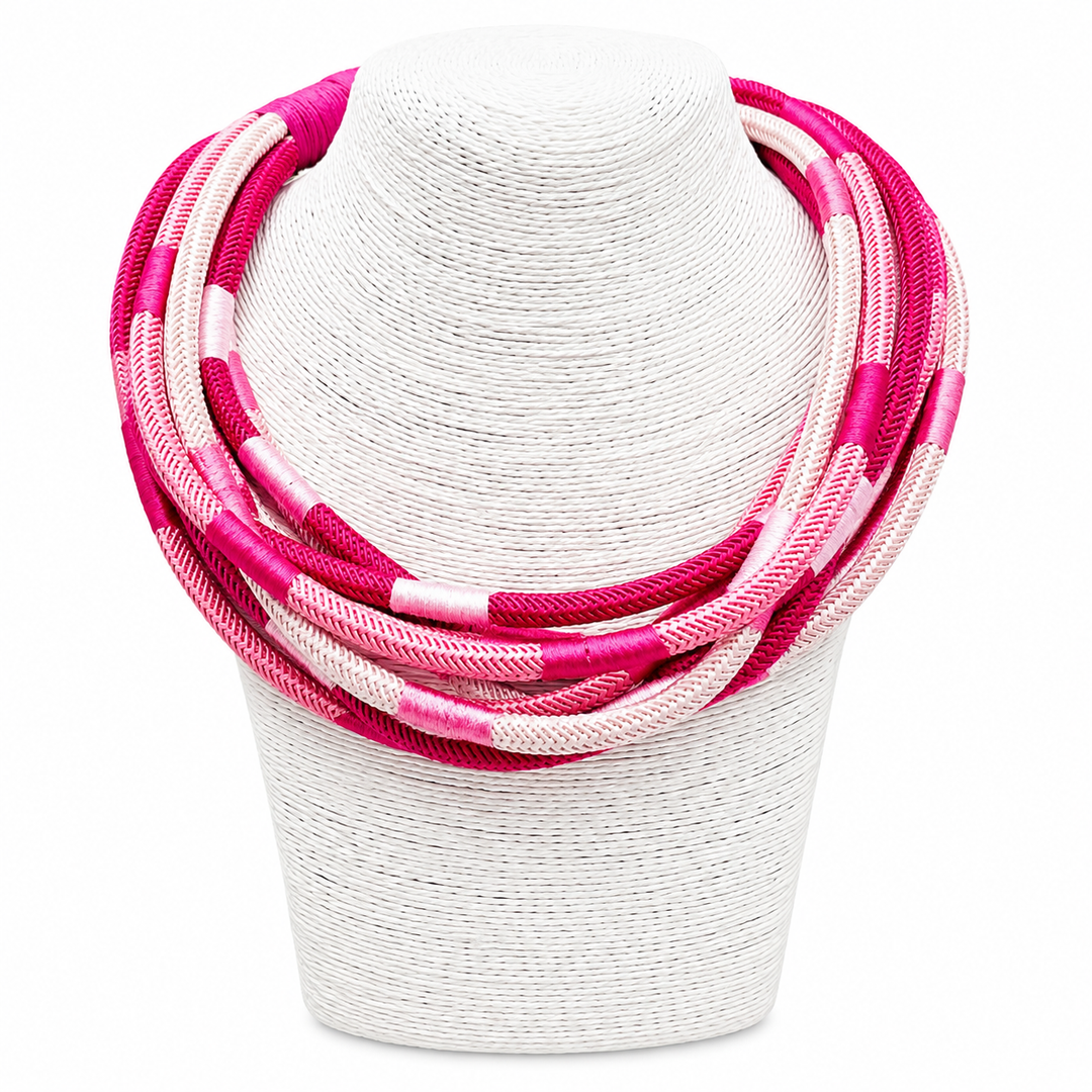 Necklace with pink and white braided design on a white stand