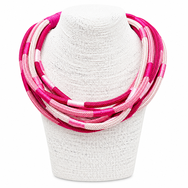 Necklace with pink and white braided design on a white stand