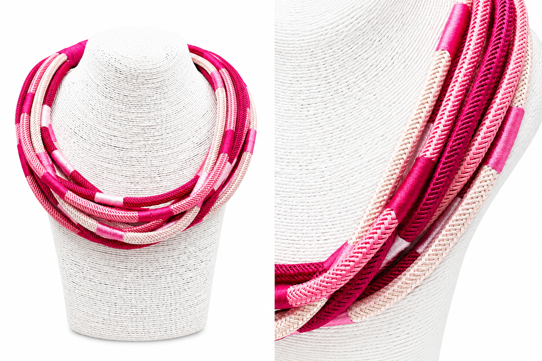 Variety of pinks in a striped necklace on a white stand