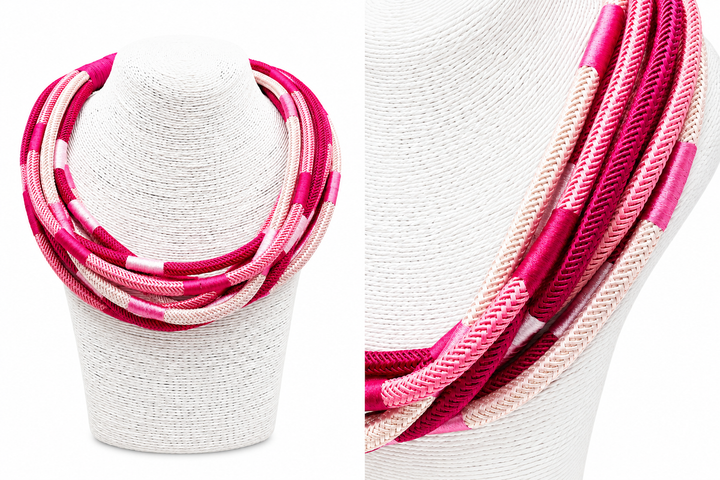 Variety of pinks in a striped necklace on a white stand