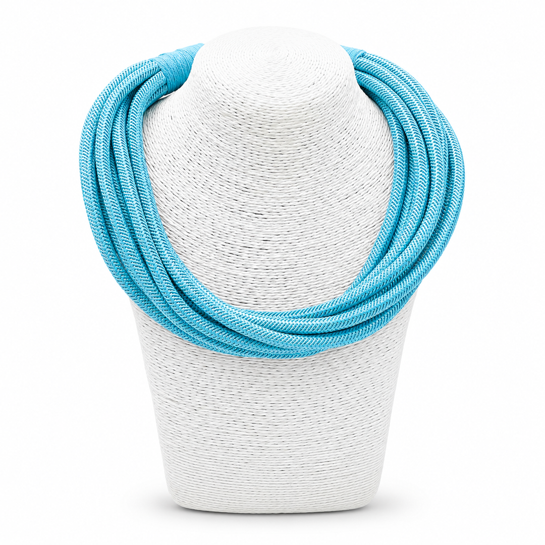 Turquoise necklace on a white mannequin bust against a white background