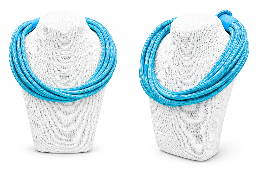 Blue necklace on a white textured stand against a white background
