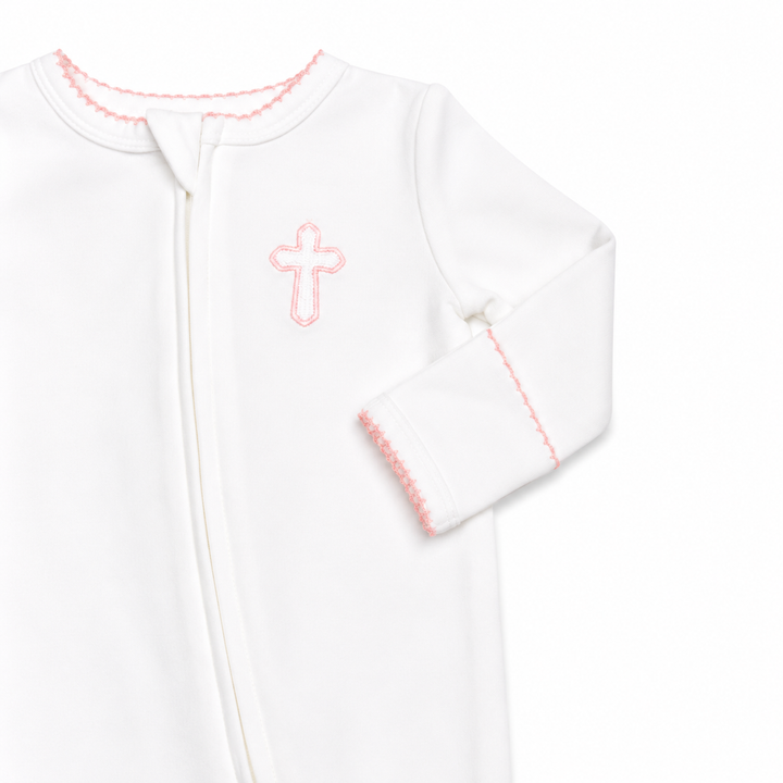 White baby onesie with pink cross design on a white background